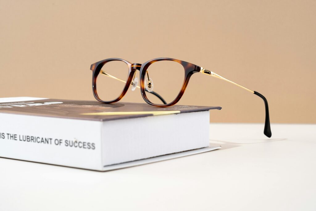 Stylish tortoiseshell eyeglasses resting on a hardcover book with motivational text.